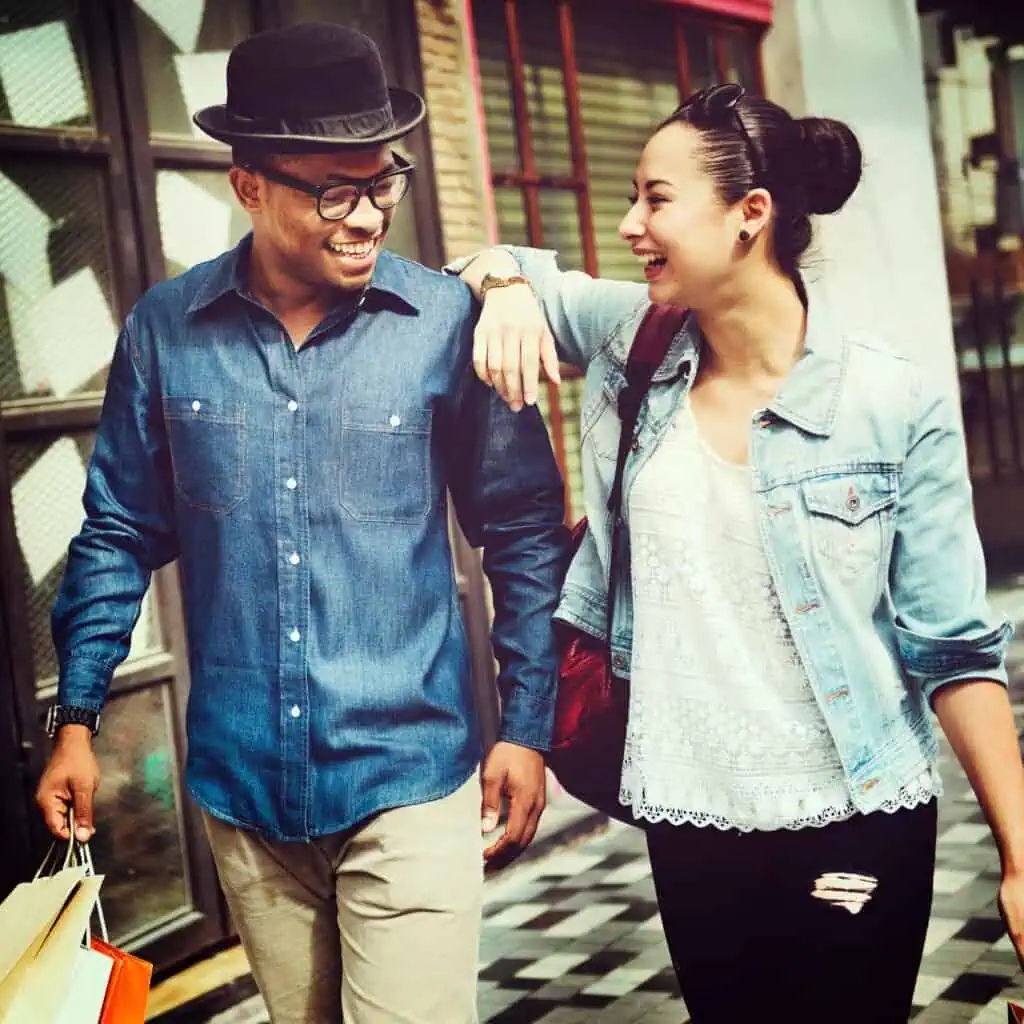 Happy couple walking together in an urban shopping district.