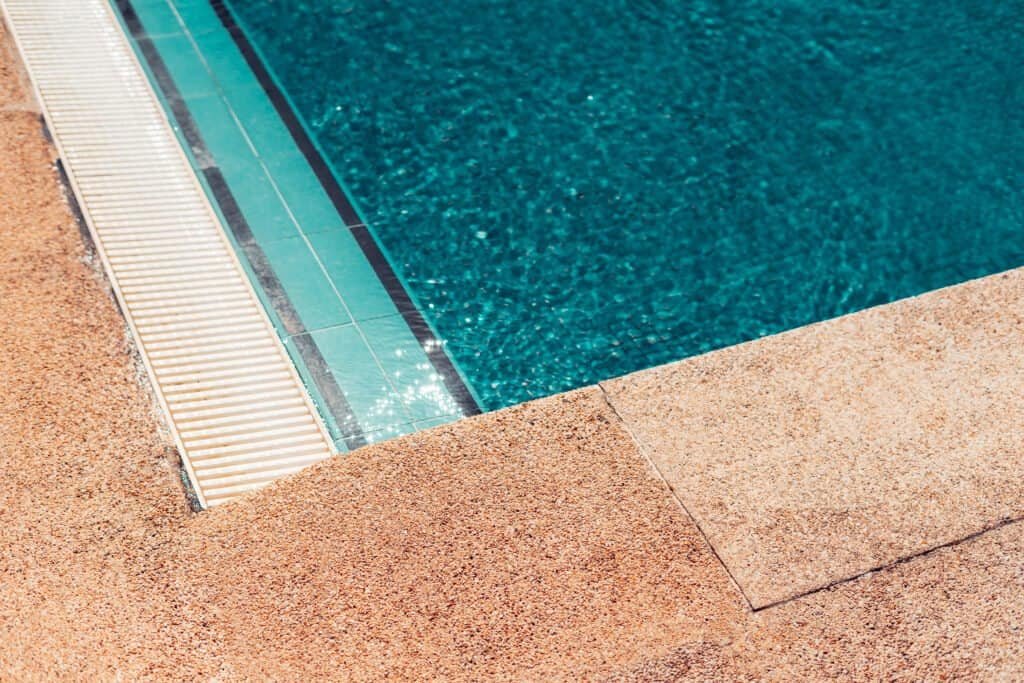 Custom swimming pool with clean water and surrounding deck.